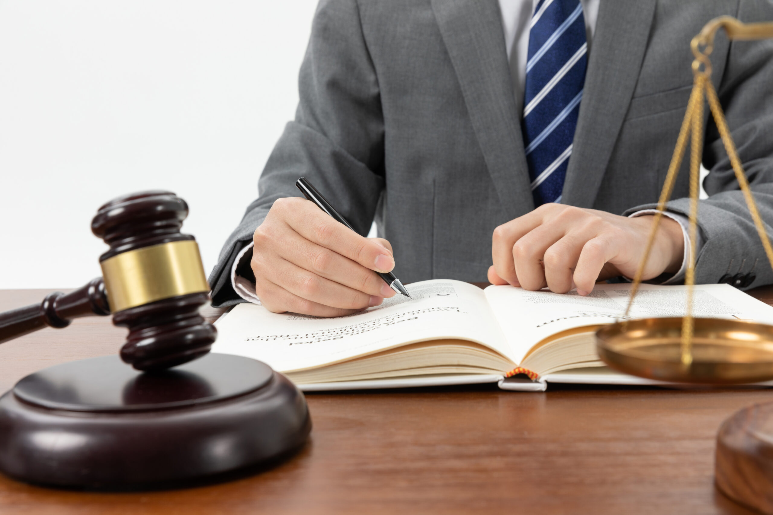 closeup-shot-person-writing-book-with-gavel-table closeup-shot-person-writing-book-with-gavel-table